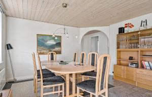 ein Esszimmer mit einem Holztisch und Stühlen in der Unterkunft Four-Bedroom Holiday Home In Sydals in Skovbyballe