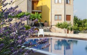 een plant met paarse bloemen naast een zwembad bij Awesome Home In Svib With Wifi in Svib