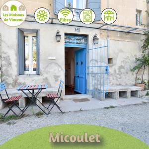 um edifício com uma porta azul e uma mesa e cadeiras em Micoulet, Parking - Clim em Arles
