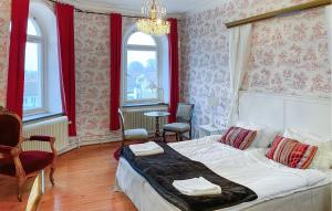 a bedroom with a large bed with red curtains at 4 Bedroom Gorgeous Home In Norrkping in Norrköping