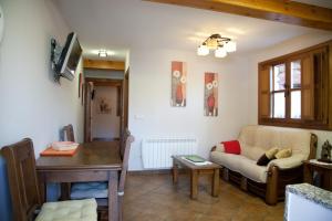 a living room with a couch and a table at Apartamentos Valdecarzana Senda del Oso in San Martín