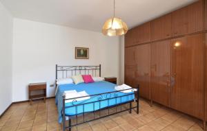 um quarto com uma cama azul e armários de madeira em 2 Bedroom Lovely Apartment In Bagolino, F, P,caffaro em Ponte Caffaro