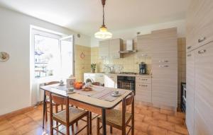 uma cozinha com mesa e cadeiras e uma cozinha com electrodomésticos brancos em 2 Bedroom Lovely Apartment In Bagolino, F, P,caffaro em Ponte Caffaro