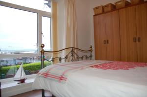 a bedroom with a bed and a large window at Beach Vista Apartment One in Barmouth in Barmouth
