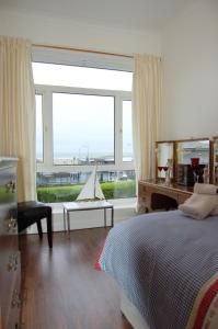 a bedroom with a bed and a large window at Beach Vista Apartment One in Barmouth in Barmouth