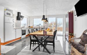 cocina y comedor con mesa de madera y sillas en Gorgeous Home In Assens With Kitchen, en Assens