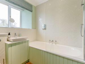 y baño con bañera y lavamanos. en 2 Bed in Blair Drummond 81513, en Doune