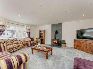 a living room with couches and a tv and a fireplace at 4 Bed in Penygroes 86423 in Pen-y-groes