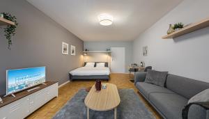 uma sala de estar com um sofá e uma cama em Richemont Residence by Homenhancement em Genebra