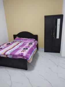 a bed with a purple comforter in a room at Urban Lifestyle in Dubai