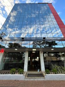 a glass building with a reflection of the sky at Imperador Palace Hotel Franca in Franca