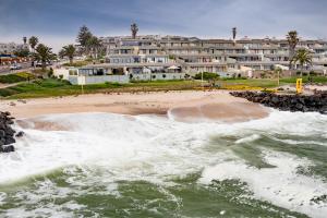 a view of a beach with a building in the background at On the Beach at Molensicht 12 in Swakopmund