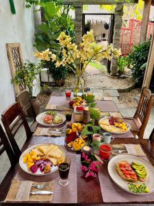 a wooden table with plates of food on it at Pao Homes - An Bang Beach Stone Villa in An Bang