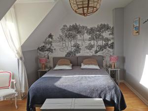 - une chambre avec un lit et une peinture murale dans l'établissement Plage du Pont - Chambres d'Hôtes, à Saint-Malo