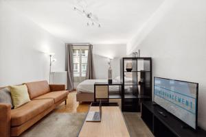 a living room with a couch and a tv at Richemont Residence by Homenhancement in Geneva