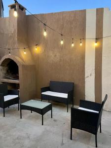 grupa krzeseł i stołów z oświetleniem na patio w obiekcie Hostel Las Pibas w mieście Sarmiento