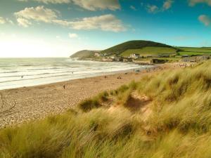 a beach with a bunch of people in the ocean at 1 Bed in Croyde 75270 in Marwood