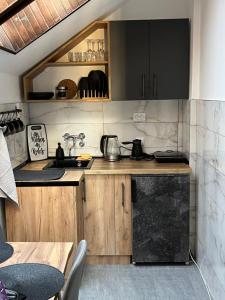 uma cozinha com armários de madeira e um frigorífico preto em Stanoteka em Vrnjačka Banja