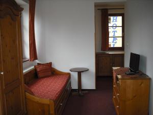 a room with a bed and a table and a window at Sport hotel POMI in Harrachov