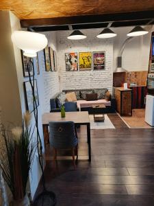 a living room with a table and a couch at Authentic Belgrade Centre - Split level loft with patio in courtyard in Belgrade