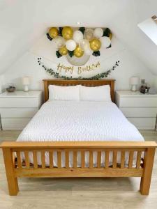 a bedroom with a bed with balloons on the wall at Meadow Guesthouse - Private Hot Tub in Rossett