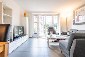 Una sala de estar con un sofá y un televisor. en Haus Maybachstraße, en Westerland