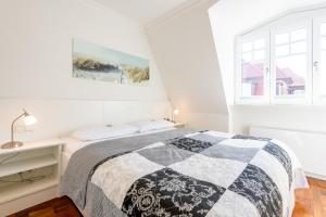 Un dormitorio blanco con una cama y una ventana. en Haus Maybachstraße, en Westerland