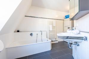 Un baño blanco con bañera y lavabo. en Haus Maybachstraße, en Westerland 41 fotos más