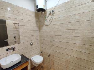 a bathroom with wooden walls and a toilet and a sink at HOTEL D.S in Amritsar