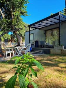 une maison avec une table et des chaises dans une cour dans l'établissement Casa Container Camisão, 