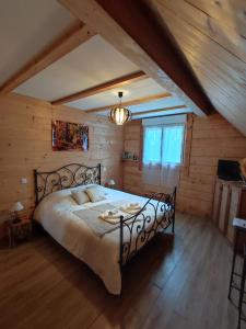 ein Schlafzimmer mit einem großen Bett in einem Zimmer mit Holzwänden in der Unterkunft Le chalet des 4 saisons in Mers-sur-Indre