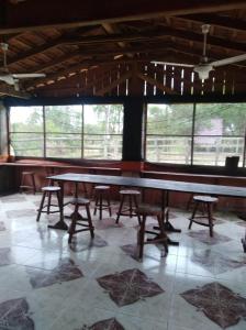 une pièce avec une table, des chaises et des fenêtres dans l'établissement Rancho Abuela Angela, à Ayolas