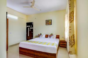 een slaapkamer met een bed en een plafondventilator bij OYO Capital O Swayamkrushi Arcade in Bangalore