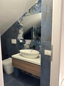 a bathroom with a sink and a toilet at Fronte lago , mansarda da favola in Trevignano Romano