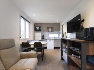 a kitchen and living room with a couch and a table at Residence Louis Quartier Des Lilas in Vittel