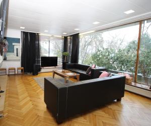 a living room with black furniture and a large window at Suuri talo Kaskisaaressa lähellä Helsingin keskustaa in Helsinki