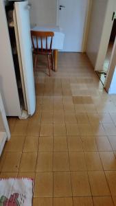 a kitchen with a tiled floor with a table and a chair at 2 quartos Icaraí in Niterói