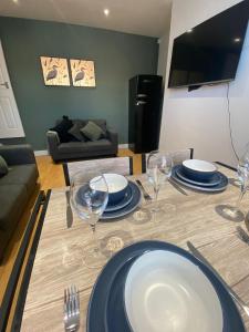 a dining table with plates and wine glasses on it at Elegant 4 Bed House - 5 minutes from Leeds in Headingley