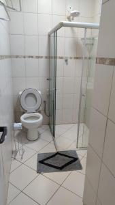 a bathroom with a toilet and a glass shower at 2 quartos Icaraí in Niterói