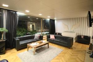 Sala de estar con sofás negros y mesa de centro en Suuri talo Kaskisaaressa lähellä Helsingin keskustaa, en Helsinki