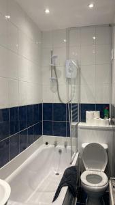 a bathroom with a tub and a toilet and a sink at Elegant 4 Bed House - 5 minutes from Leeds in Headingley
