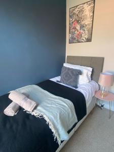 a bedroom with a bed with a blue wall at Elegant 4 Bed House - 5 minutes from Leeds in Headingley