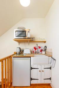 a kitchen with a microwave on top of a counter at The Nest in Wells next the Sea