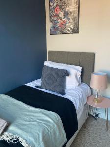 1 dormitorio con 1 cama con pared azul en Elegant 4 Bed House - 5 minutes from Leeds, en Headingley