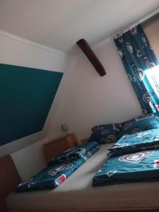 a bedroom with a bed with blue pillows on it at Domek na Mazurach Ełk. Rogale in Stare Juchy