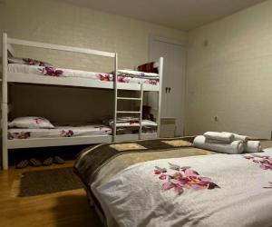 um quarto com 2 beliches com flores na cama em APARTMENT Marash em Prizren