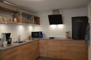 a kitchen with a sink and a black refrigerator at Beim Bergschreiner in Obergünzburg