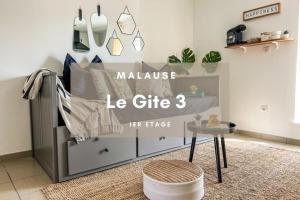 a bedroom with a bed with a sign that says maluce le gift three at Le Gite 3 - Studio confort, 10min Golfech in Malause