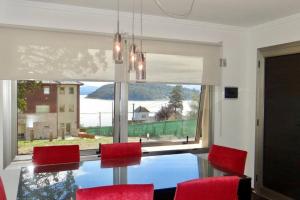 a dining room with a table and chairs and a large window at Complejo Quinta Luna, módulo Araucaria in San Carlos de Bariloche +4 photos
