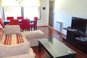 a living room with a couch and a tv and a table at Complejo Quinta Luna, módulo Araucaria in San Carlos de Bariloche